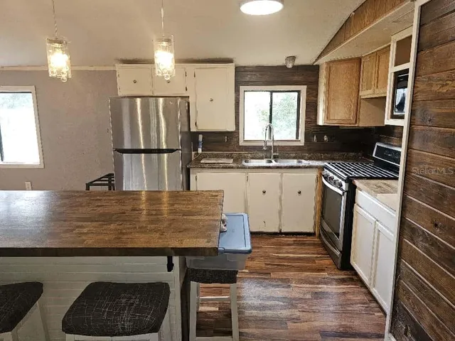 a kitchen with kitchen island granite countertop a sink stove and refrigerator