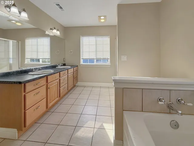 a large white kitchen with a sink a stove and a window