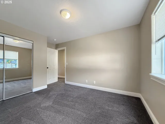 an empty room with windows and closet