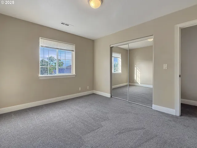 an empty room with windows and closet
