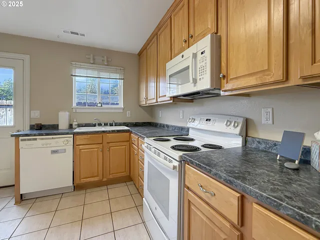 a kitchen with stainless steel appliances granite countertop a stove a sink and a microwave