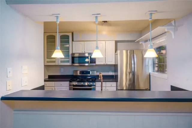 a kitchen with kitchen island a sink stainless steel appliances and counter space