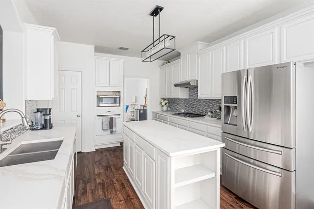 a kitchen with stainless steel appliances a refrigerator sink and cabinets