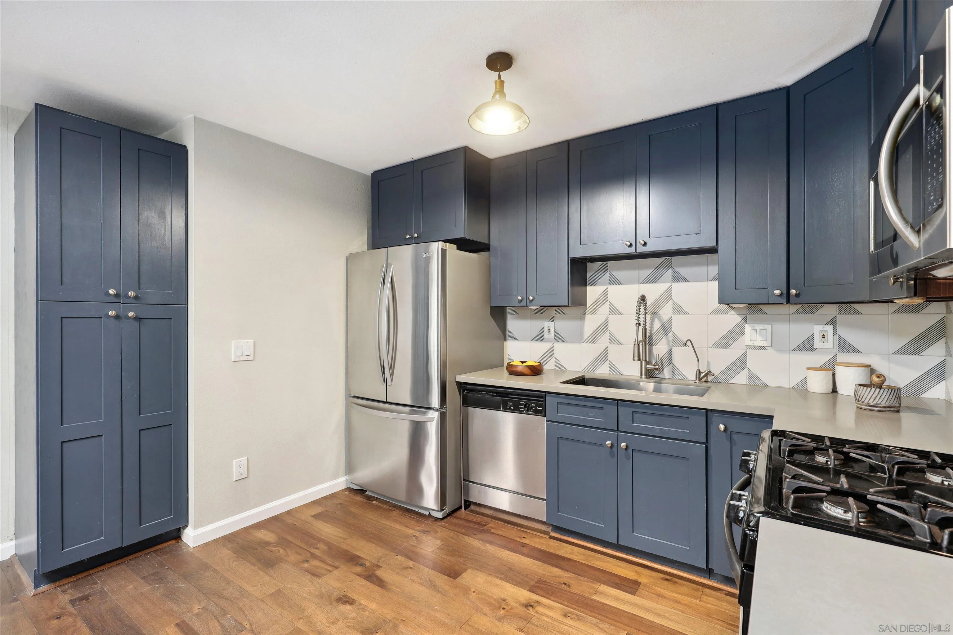 1390 Orpheus Avenue Encinitas, CA 92024 - Photo 13 of 32 a kitchen with granite countertop a refrigerator and a stove top oven