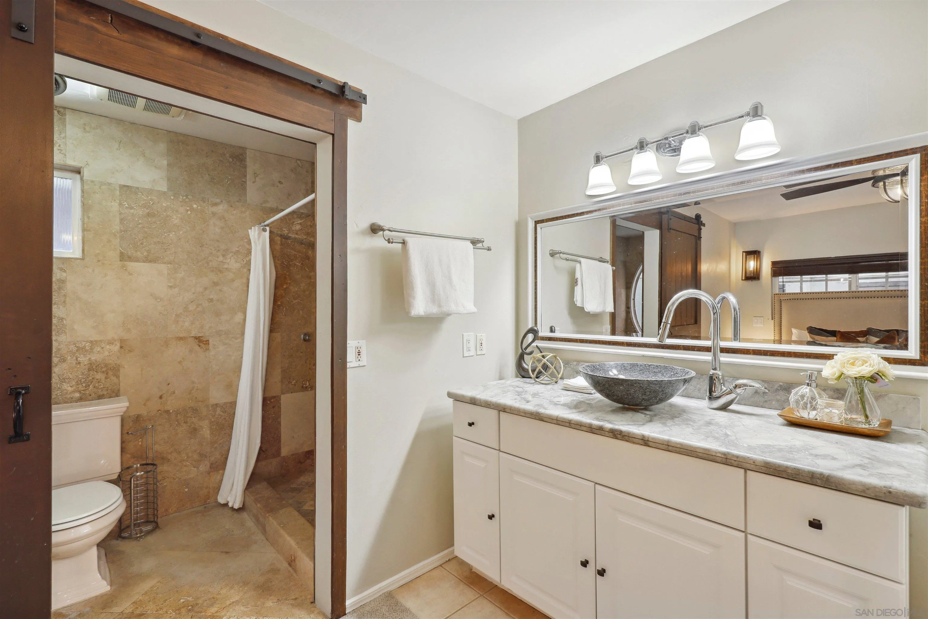 1390 Orpheus Avenue Encinitas, CA 92024 - Photo 22 of 32 a bathroom with a granite countertop sink a toilet and a mirror
