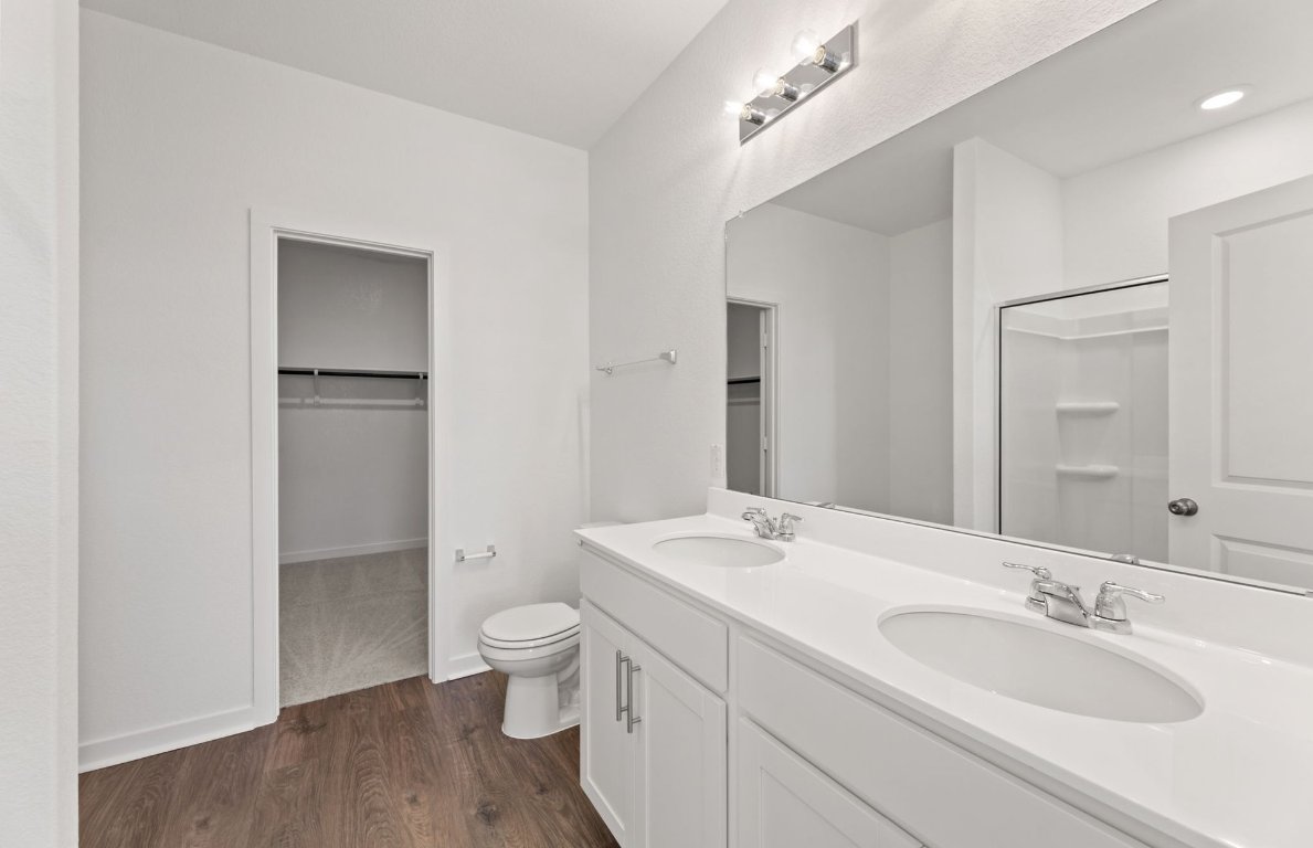 401 The Duke Drive Jarrell, TX 76537 - Photo 12 of 25 a bathroom with a granite countertop sink a toilet and a large mirror