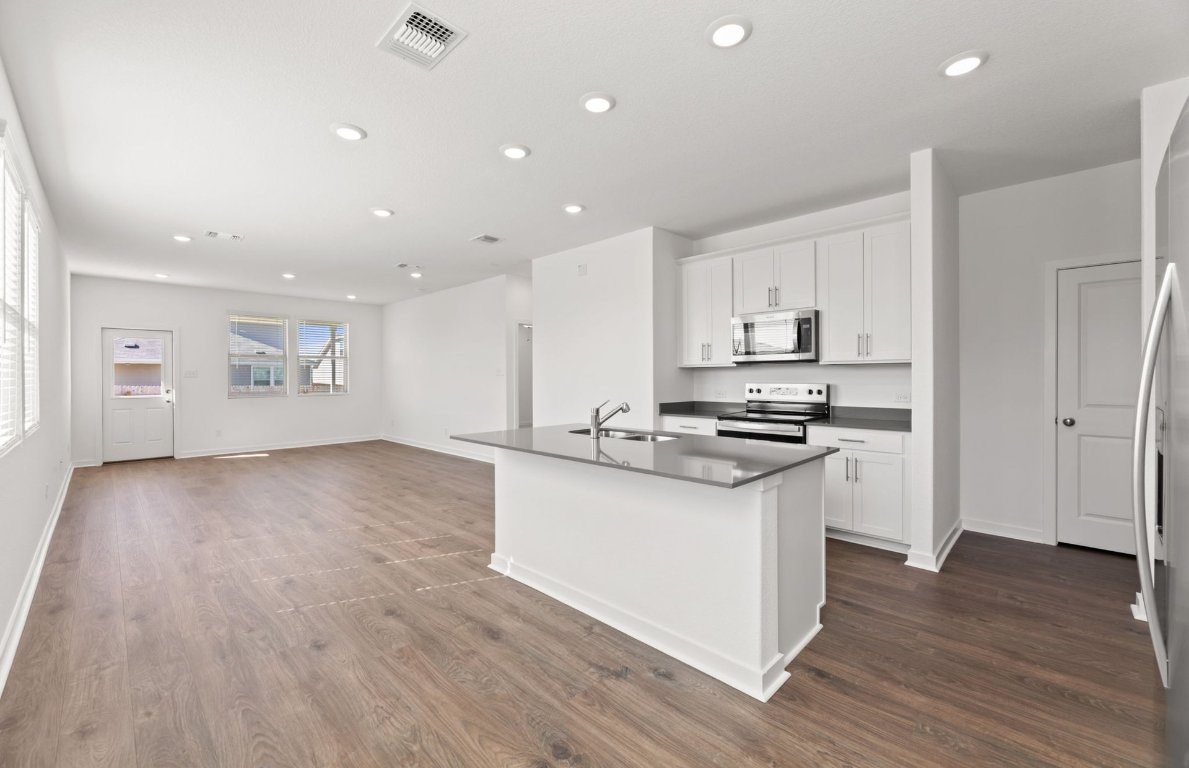 401 The Duke Drive Jarrell, TX 76537 - Photo 3 of 25 a kitchen with stainless steel appliances granite countertop a stove and a refrigerator