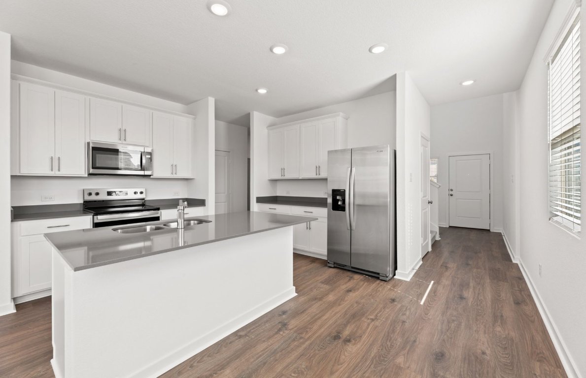 401 The Duke Drive Jarrell, TX 76537 - Photo 4 of 25 a kitchen with stainless steel appliances a refrigerator sink and microwave