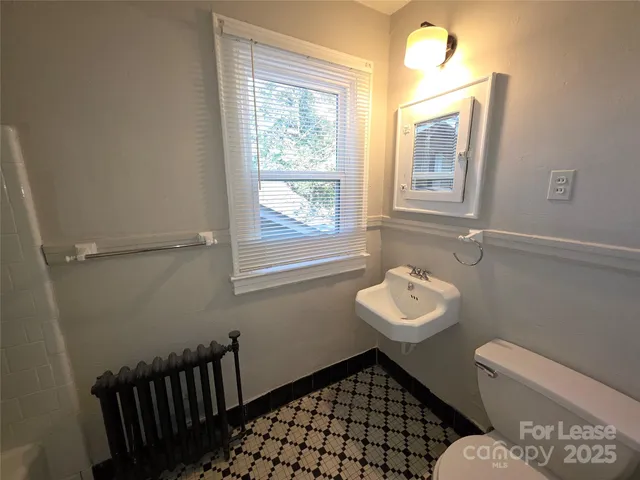 a bathroom with a sink toilet and a window