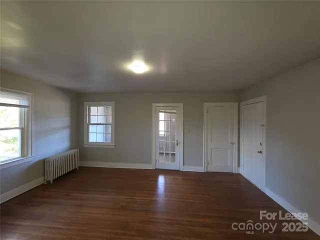 an empty room with window and wooden floor