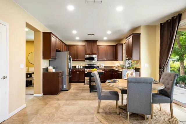 a kitchen with stainless steel appliances granite countertop sink stove top oven and cabinets