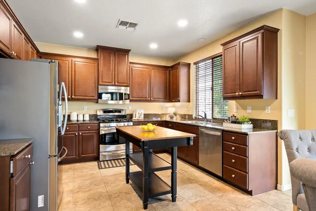 a kitchen with stainless steel appliances granite countertop sink stove top oven and cabinets