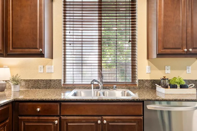 a kitchen with granite countertop a sink and a window