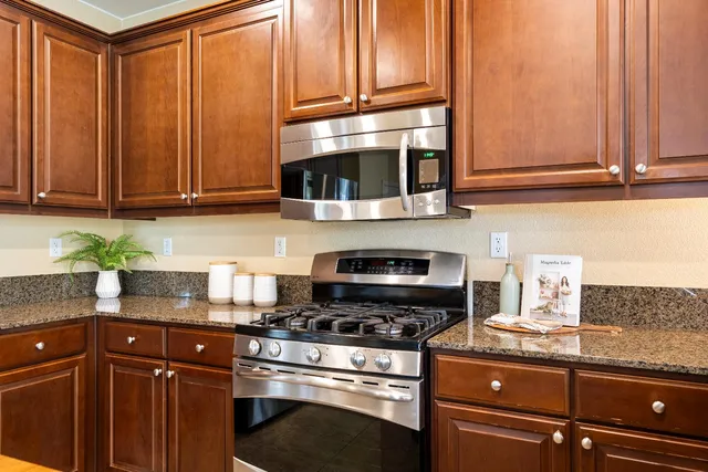 a kitchen with granite countertop wood cabinets and stainless steel appliances