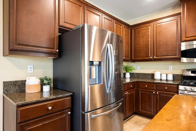 a kitchen with stainless steel appliances granite countertop a refrigerator and a sink