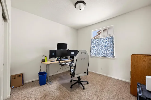 a view of a workspace with furniture and a window
