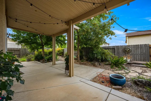 a view of a patio with chairs and potted plants