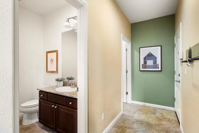 a bathroom with a granite countertop sink a mirror and a toilet