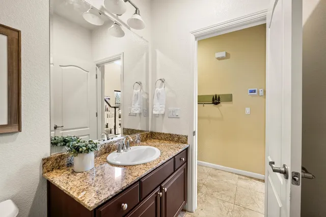 a bathroom with a granite countertop sink a mirror and a shower