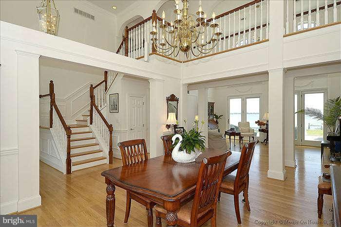 2805 Cox Neck Road Chester, MD 21619 - Photo 10 of 30 a view of a dining room and livingroom with furniture wooden floor a chandelier