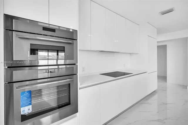 a large white kitchen with a large window