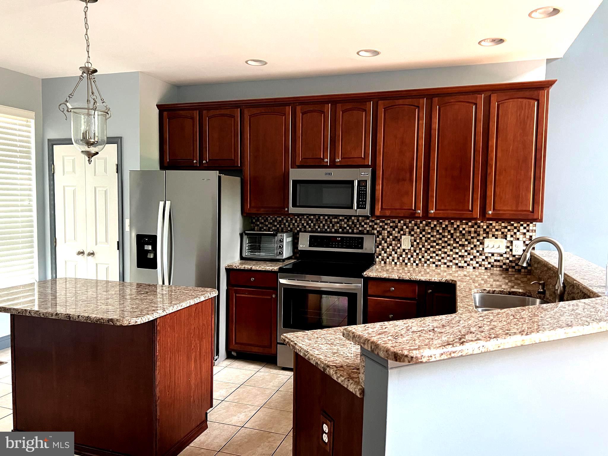 120 Dispatch Drive, Unit 77 Washington Crossing, PA 18977 - Photo 6 of 22 a kitchen with granite countertop wooden cabinets and stainless steel appliances