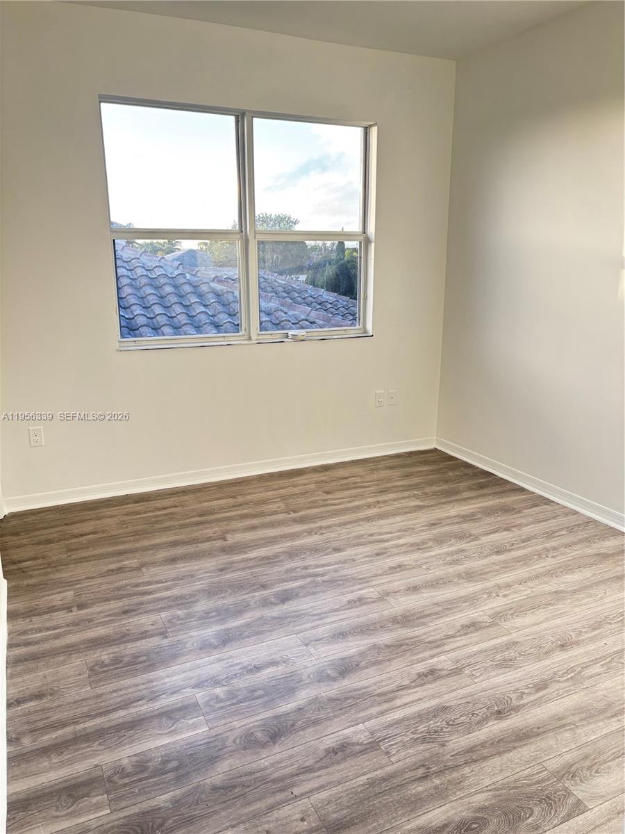 15041 Southwest 177th Terrace Miami, FL 33187 - Photo 12 of 12 an empty room with wooden floor and windows
