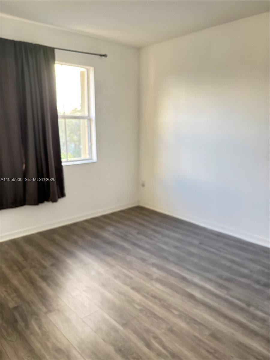 15041 Southwest 177th Terrace Miami, FL 33187 - Photo 8 of 12 an empty room with wooden floor and windows