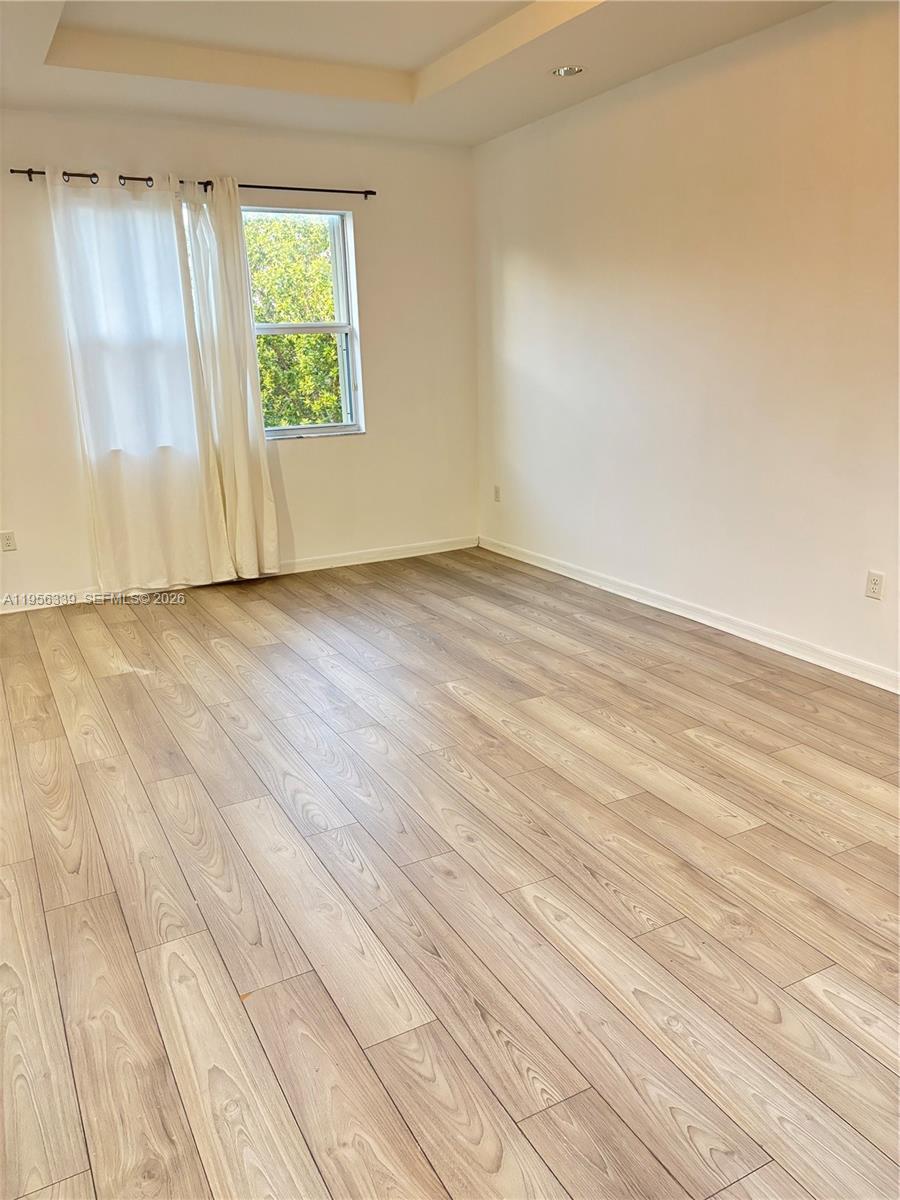 15041 Southwest 177th Terrace Miami, FL 33187 - Photo 9 of 12 an empty room with wooden floor and windows