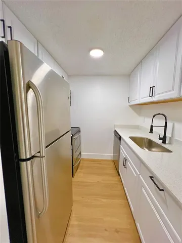 a kitchen with stainless steel appliances a refrigerator sink and cabinets