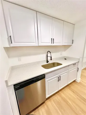 a kitchen with a sink cabinets and a wooden floor