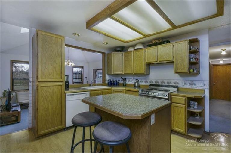 21645 Northeast Butler Market Road Bend, OR 97701 - Photo 3 of 13 a kitchen with a table chairs sink and cabinets