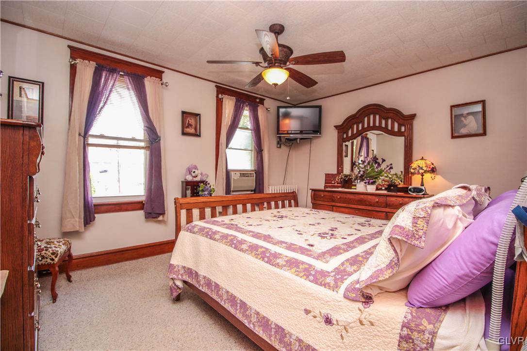 1139 Spring Garden Street Easton, PA 18042 - Photo 14 of 26 a spacious bedroom with a bed a chandelier and a large window
