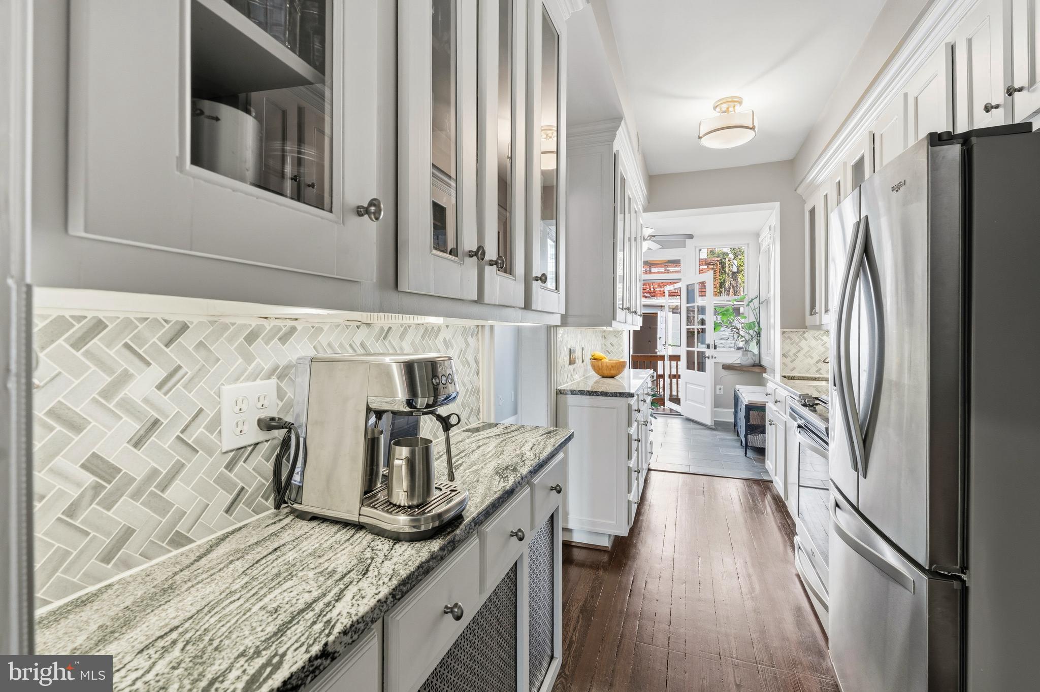148 Todd Place Northeast Washington, DC 20002 - Photo 13 of 43 a kitchen with granite countertop a refrigerator a stove and a wooden floor