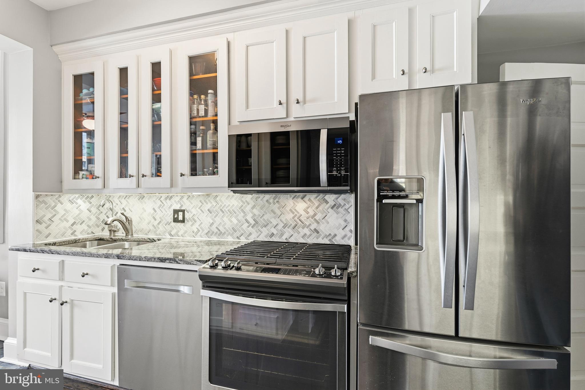 148 Todd Place Northeast Washington, DC 20002 - Photo 14 of 43 a kitchen with stainless steel appliances granite countertop a refrigerator stove and white cabinets