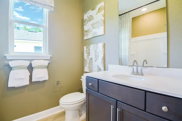 a bathroom with a toilet sink and mirror