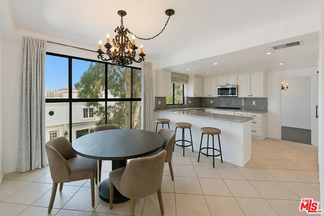 a kitchen with granite countertop a sink a stove and cabinets