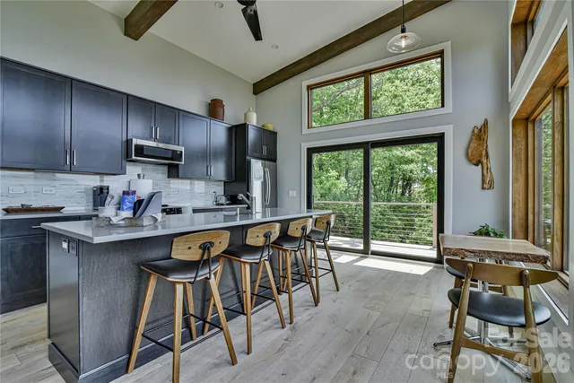 a kitchen with stainless steel appliances granite countertop a sink dishwasher a stove refrigerator and cabinets with wooden floor