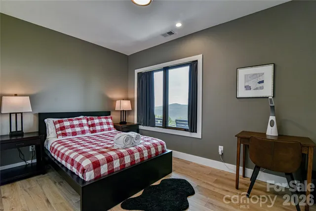 a bedroom with a bed and wooden floor