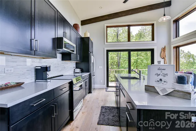 a kitchen with stainless steel appliances granite countertop a sink and a stove