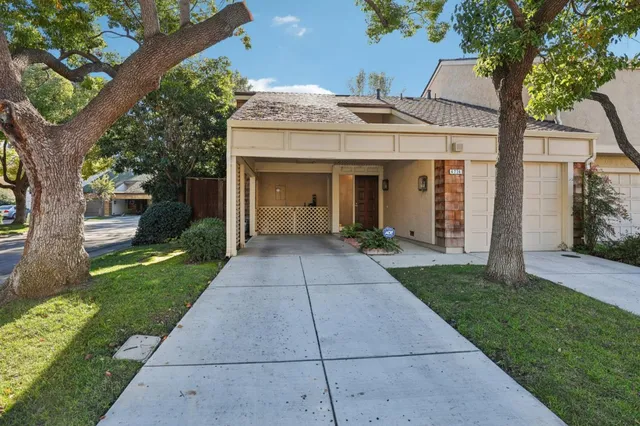 a front view of a house with a garden and trees