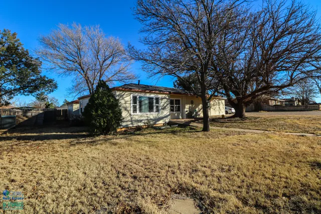 a view of house with yard covered with snow and trees