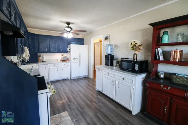 a kitchen with granite countertop a sink dishwasher stove and wooden cabinets