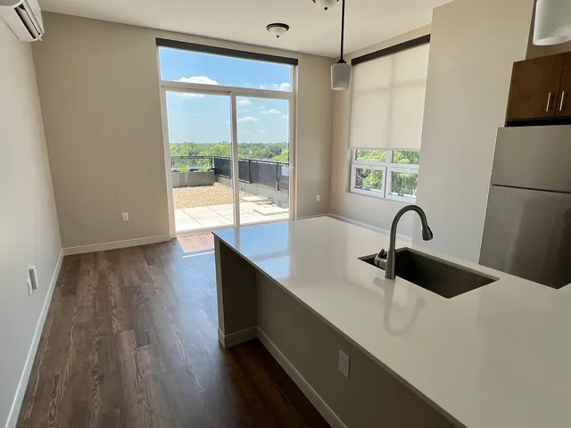 a kitchen with a sink a counter top space and a large window