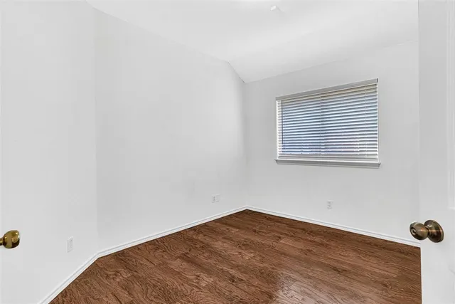 a view of a room with wooden floor and a window