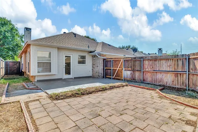 a view of backyard of house with wooden fence