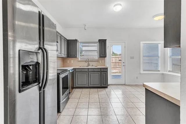 a kitchen with stainless steel appliances a stove a sink and a refrigerator