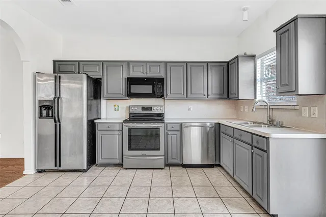 a kitchen with a sink a microwave and refrigerator