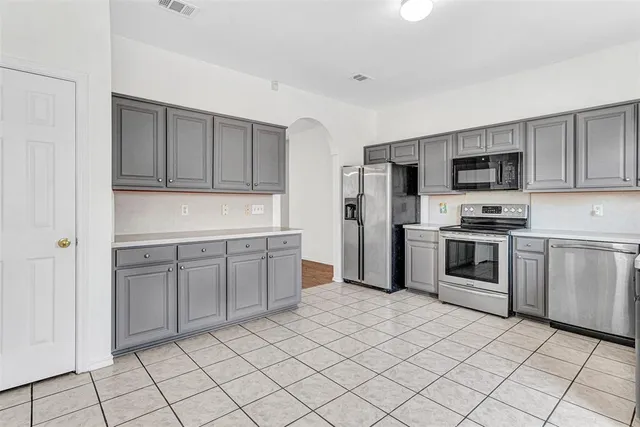 a kitchen with granite countertop a refrigerator sink and cabinets