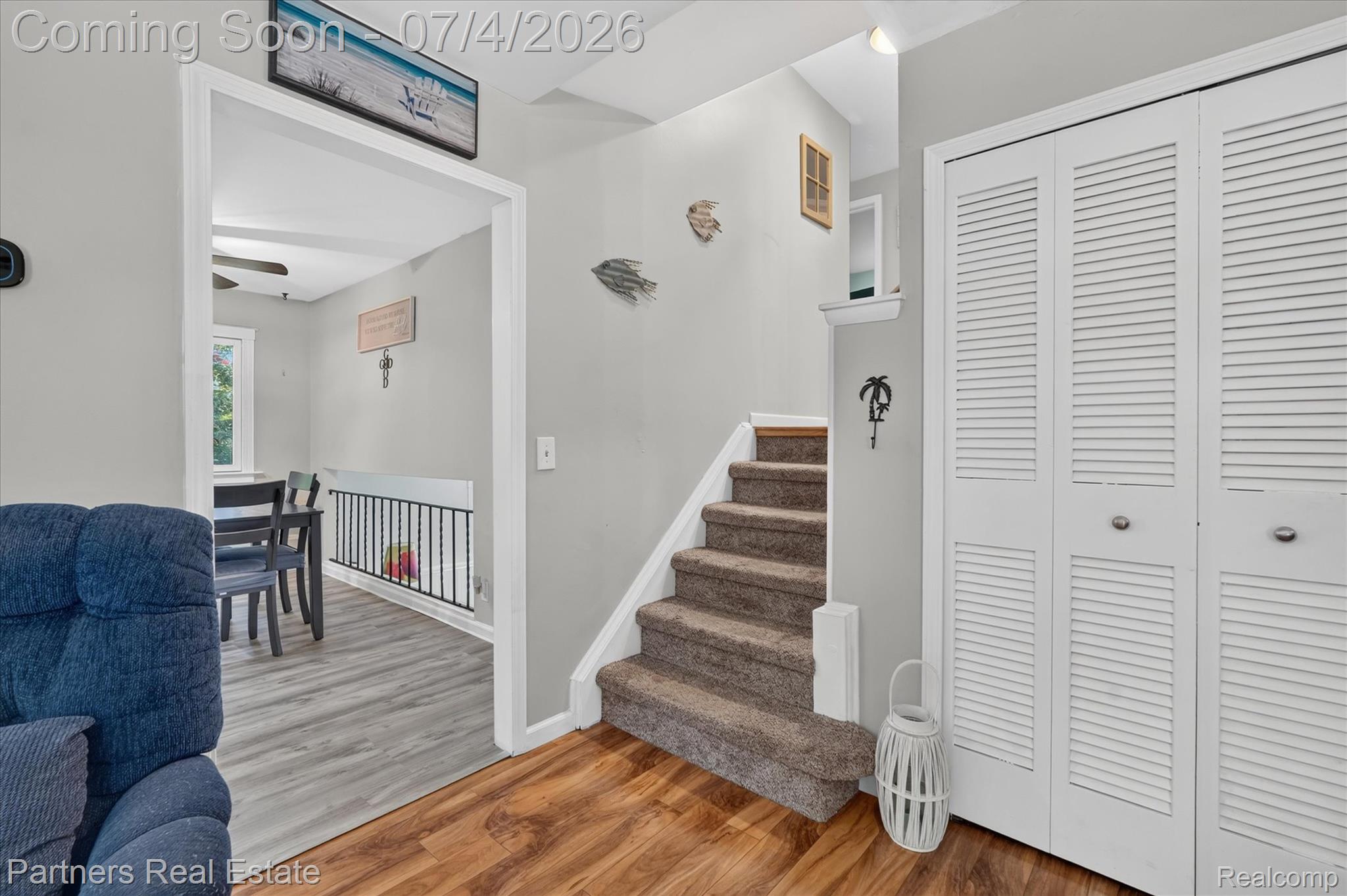 2500 Hubert Road Brighton, MI 48114 - Photo 17 of 53 Carpeted staircase featuring white trim, a coat closet with louvered bifold doors, and wood-finish flooring